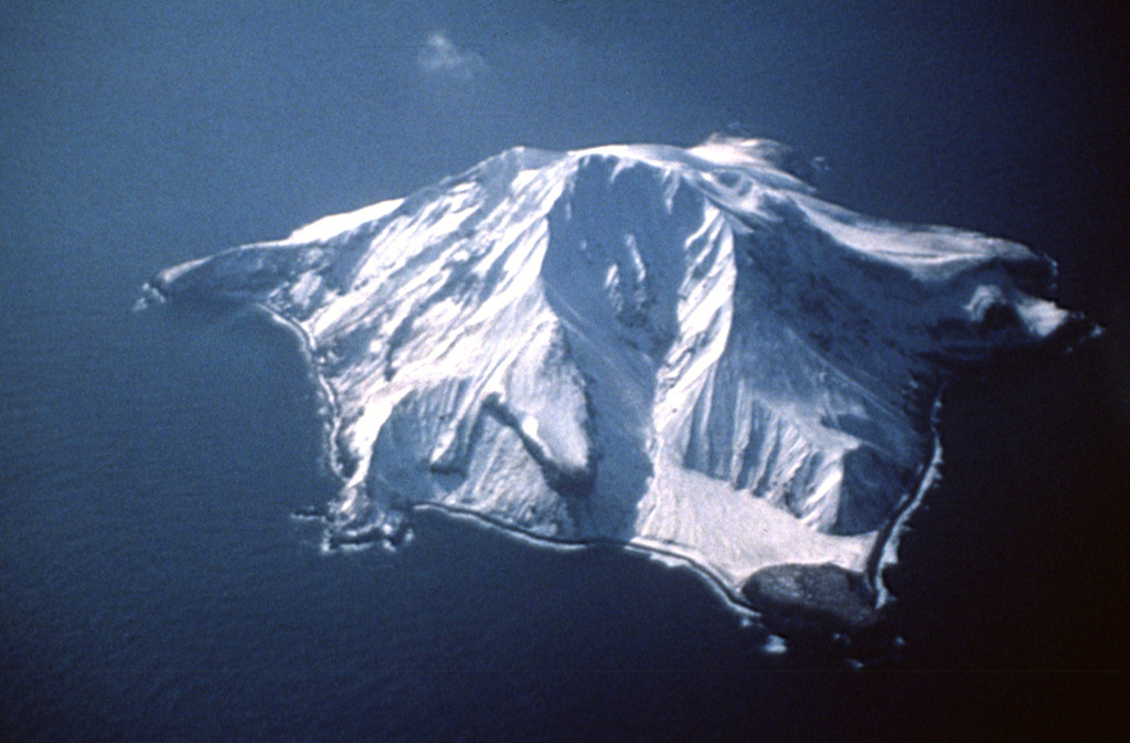 The small 3 x 4 km Bobrof volcanic island lies 50 km W of Adak and 15 km W of Kanaga volcano. The irregular shoreline has a half-dozen small cliff-bound peninsulas. The geology and timing of volcanism on Bobrof are unknown, but pyroclastic flow deposits are present. Photo courtesy of Alaska Volcano Observatory, U.S. Geological Survey.