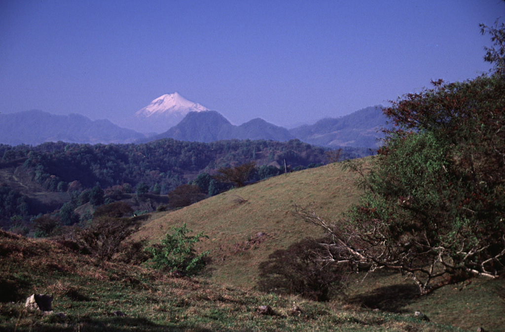 Glaciated Pico de Orizaba (Citlaltépetl) rises 50 km to the SW above rolling terrain south of the town of Xico, on the lower flanks of Cofre de Perote.  Photo by Lee Siebert, 2000 (Smithsonian Institution).