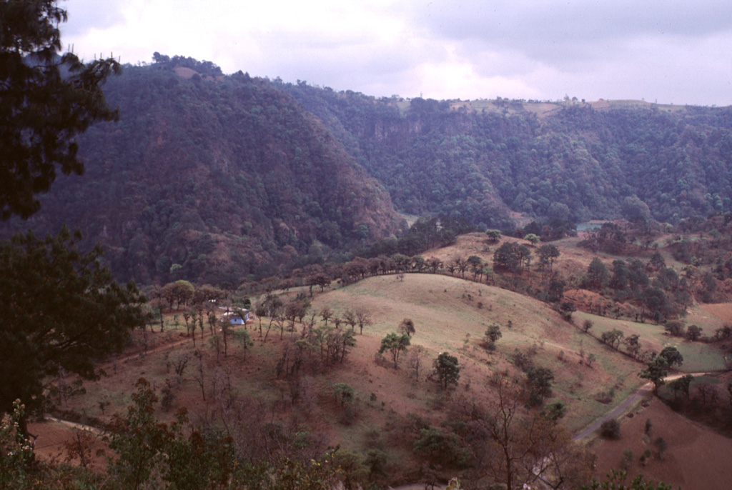 The rounded ridge in the foreground is the tephra-mantled surface of a lava flow erupted from the base of the Rincón de Chapultepec scoria cone about 3,000 years ago. This 50-m-thick lobe was extruded for a distance of 2 km to the south on top of an earlier olivine-basaltic lava flow that filled the valley floor and traveled 6 km from the vent. Photo by Lee Siebert, 2000 (Smithsonian Institution).