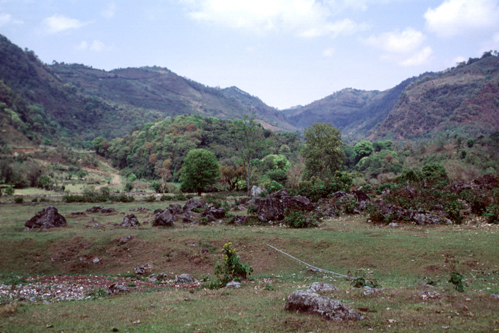 The Puebla Vieja cone along the horizon to the left is one of the westernmost cones of the Naolinco Volcanic Field. The forested hill in the center of the photo is the distal portion of a lava flow that traveled to the SE down the valley floor. In the foreground are exposures of the Coacoatzintla lava flow from the Rincón de Chapultepec cone. Photo by Lee Siebert, 2000 (Smithsonian Institution).