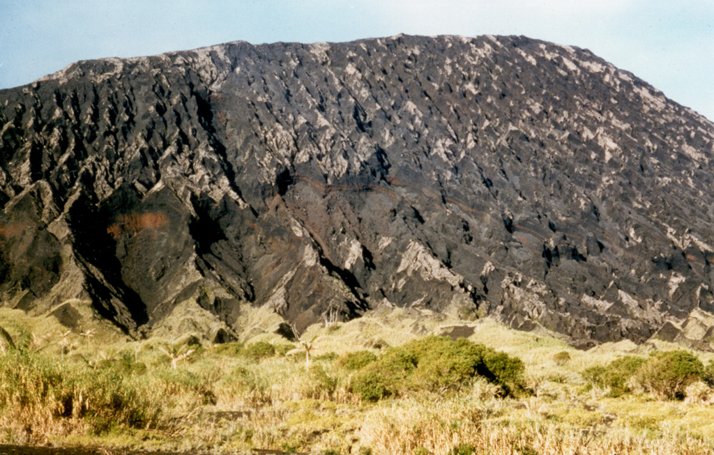 The ash-mantled slopes of the northern side of Marum cone are cut by erosional furrows. Marum is one of several historically active cones constructed within the 12-km-wide caldera of Ambrym. The cone lies in the west-central part of the caldera and is the highest of the post-caldera cones. Photo by Alain Melchior.