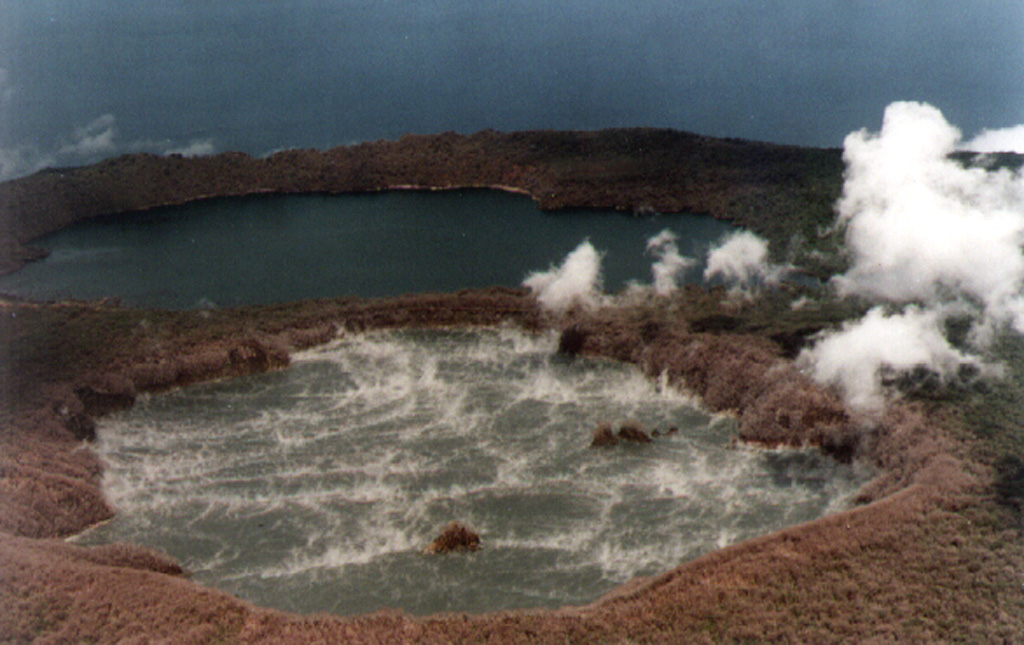 The summit of Ambae is seen looking approximately SE, with Lake Voui (foreground) and Lake Manaro Lakua (also known as Manaro Ngoru) on 20 March 1995. This was following an eruption on 2 March when bubbling and black sediment ejection were observed; the next day a 3-km-high steam-and-ash plume ejected lake sediments. Convection cells ~300-400 m in diameter can be seen in Lake Voui. The eruption took place near the center of the lake, between the two small islands. No eruptive activity was observed after 3 March. Photo courtesy of ORSTOM, 1995 (published in Global Volcanism Program Bulletin).