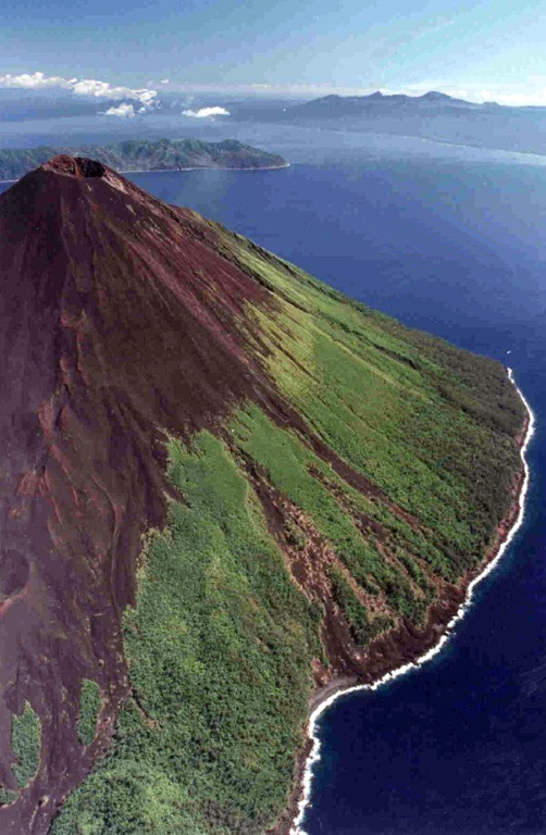 The Lopevi SE-flank eruptive fissure in May 1995 is visible in this photo. The small 7-km-wide island is frequently active with both summit and flank vents, primarily on the NW and SE sides, producing moderate explosive eruptions and lava flows that reach the coast. Historical eruptions date back to the mid-19th century. Paama Island (left) and Ambrym Island (right) are in the background to the north.  Photo by P. Evin, 1995 (Institut de Recherche pour le Développement, Vanuatu; Bull. Global Volcanism Network, 1999).