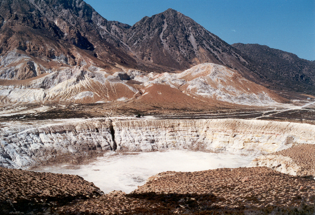 The tuff cone and crater in the foreground were formed during an eruption on the caldera floor in 1871. Phreatic explosions ejected ash and lapilli that covered the caldera floor. Five explosion craters are located in the 800 x 1,400 m caldera floor. Post-caldera lava domes form the horizon. Photo by Ichio Moriya (Kanazawa University).