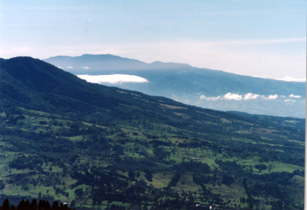 The southern flank of Barva is in the foreground of this photo, with Irazú massif to the SE in the background. One of the youngest lava flows on Barva, the Los Angeles flow, traveled down the south flank almost as far as the city of Heredia. Barva and Irazú are visible from the nation's capital city, San José out of view to the right. Irazú is sometimes known as the "Colossus" due to its size and occasionally destructive eruptions.  Photo by Ichio Moriya (Kanazawa University).