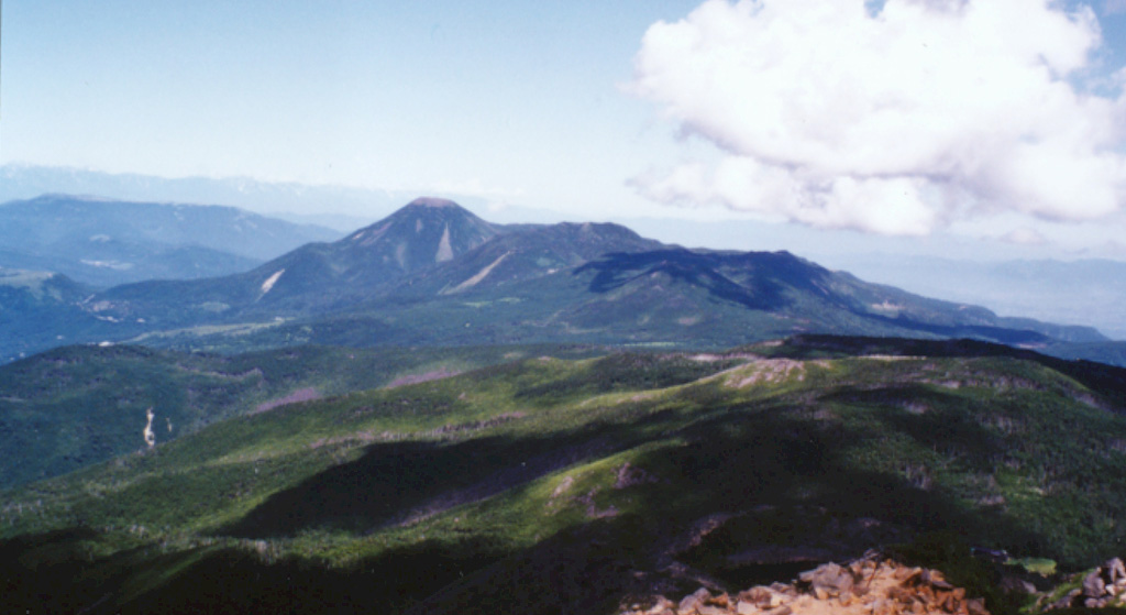 The Kita-Yatsugatake (North Yatsugatake) volcanic group is seen here from the summit of Tengudake to the south. Conical Tateshina (left-center) is a part of a group cones and lava domes at the NW end of the NNW-SSE-trending Yatsugatake volcanic massif. The broad forested slope in the foreground is Nakadake, and the flat-topped peak to the right of Tateshina is Yokodake, which last erupted about 800 years ago.  Photo by Ichio Moriya (Kanazawa University).