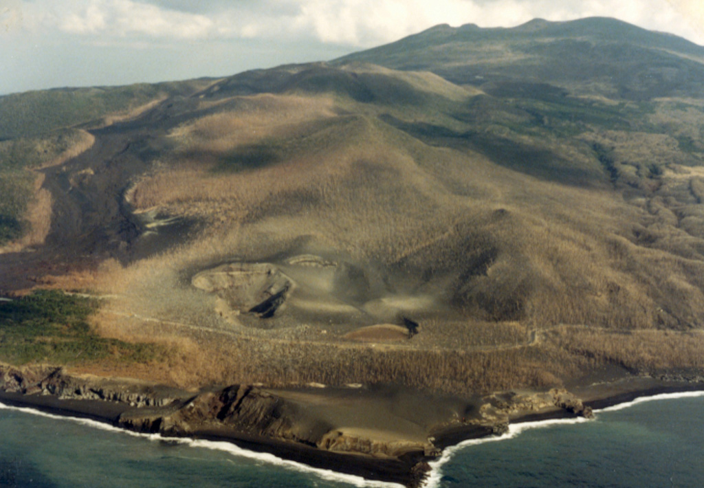 The craters in the foreground and the lava flow to the right erupted in 1983 from vents on the SW flank of Miyakejima. The 8-km-wide island rises about 1.1 km from the sea floor in the northern Izu Islands, about 200 km SSW of Tokyo. The summit cone of Oyama (upper right) lies within a caldera that formed about 3,000 years ago. Frequent eruptions have occurred since 1085 CE at vents ranging from the summit to below sea level. Photo by Ichio Moriya (Kanazawa University).