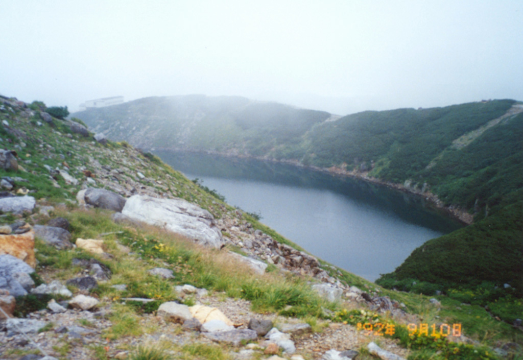 Lake-filled Mikurigaike crater is part of Tateyama, an eroded stratovolcano on a plateau surrounded by the granite and gneiss peaks of the North Japan Alps. Formation of a 4-km-wide caldera was followed by Pleistocene eruptions of lava and pyroclastics forming a plateau that was later eroded by the Yukawa river. Holocene eruptions have been restricted to small phreatic explosions that formed craters such as the one seen here. Photo by Ichio Moriya, 1992 (Kanazawa University).