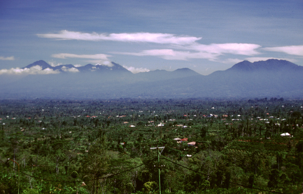 The Bratan volcanic complex is seen here from the E from the rim of Batur. The peak at the right is Pengilangan on the NE rim of the 11 x 6 km wide caldera. The caldera contains three lakes and is located between Pengilangan and the cluster of peaks at the left-center, which are post-caldera cones. The sharp peak to the far left is Batukau, S of the caldera. The area in the foreground is underlain by pyroclastic flow deposits from Batur caldera. Photo by Lee Siebert, 2000 (Smithsonian Institution).