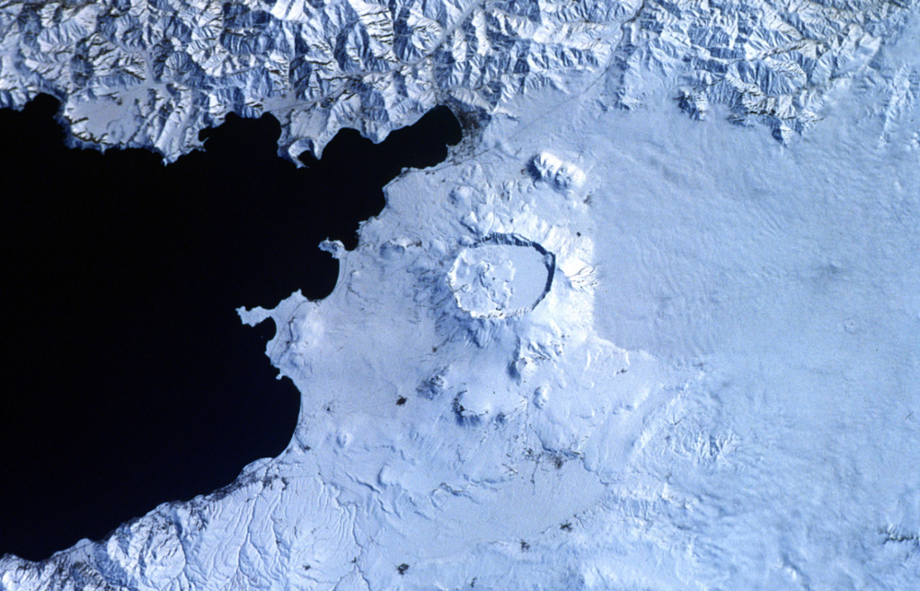 The prominent caldera in the center of the photo is Nemrut Dagi, the westernmost of a group of volcanoes near Lake Van. Nemrut Dagi lies north of the western part of Lake Van and is the only one of the group that has erupted in historical time. The 5 x 9 km caldera is partially filled by a lake, which appears as the smooth snow-covered right side of the caldera floor in this Space Shuttle photo with north to the bottom. Ash layers in Lake Van document numerous Holocene eruptions, the last of which took place in 1441 CE. NASA Space Shuttle image STS45-80-08, 1992 (http://eol.jsc.nasa.gov/).