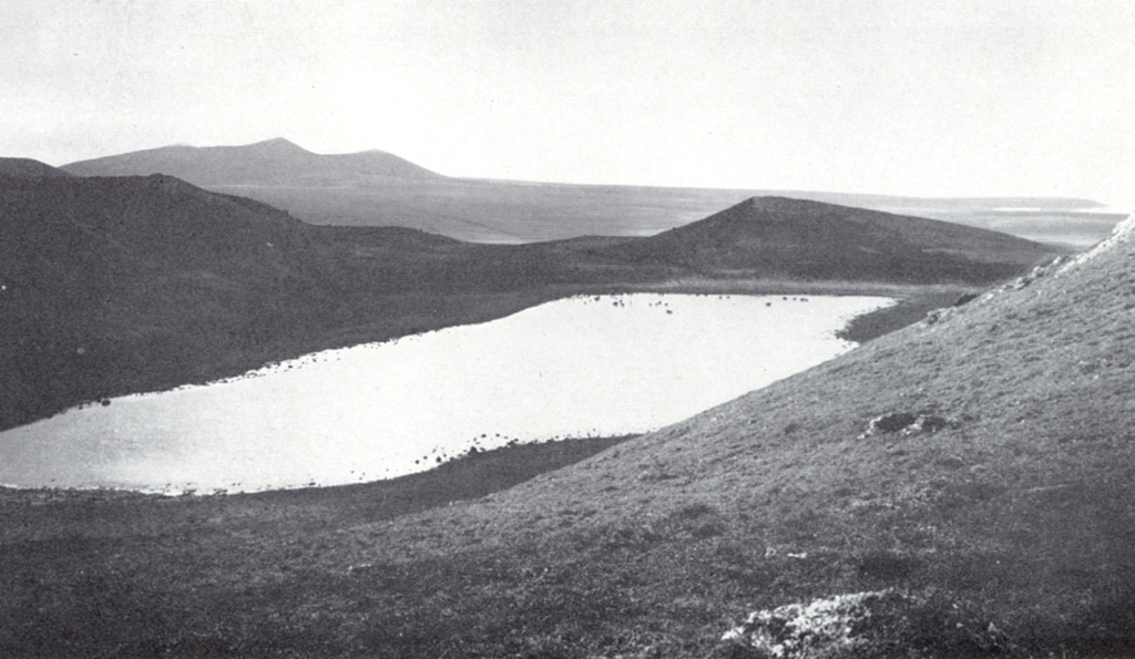 Lake-filled Crater Hill on the western side of St. Paul is one of many craters across the island. Caribou can be seen wading along the shores of the lake. The largest of the Pribilof Islands, St. Paul consists of a 110 km2 area of coalescing small edifices with a central scoria cone. The Fox Hill lava flow at the far western end of the island is estimated to be only a few thousand years old. Photo by V.B. Scheffer (published in U.S. Geological Survey Bulletin 1028-F).