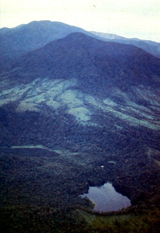 This view from the north looks across vents extending north from Poás. In the foreground is the Hule maar complex, with Laguna Bosque Alegre to the left and Laguna Congo at bottom right; the forested peak in the middle distance is Cerro Congo. Poás volcano is about 12 km to the south and forms the horizon here. Photo by Guillermo Alvarado, 1987 (Instituto Costarricense de Electricidad).