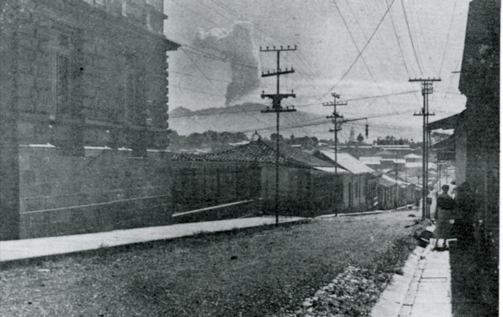 An ash plume above the Irazú summit crater is seen here in 1917 from the national theater in San José. All summit craters were reported to be active on 27 September 1917, after which activity steadily intensified. Ash fell in Curridabat on 18 November and again a month later, when ash also fell in Tres Ríos. On 6 January 1918 ashfall reached San José, Heredia, and Puriscal. Intermittent explosive activity continued until 1921, with an explosion on 30 November 1918 producing ashfall as far as Nicoya. Anonymous, 1917 (published in Alvarado, 1989).