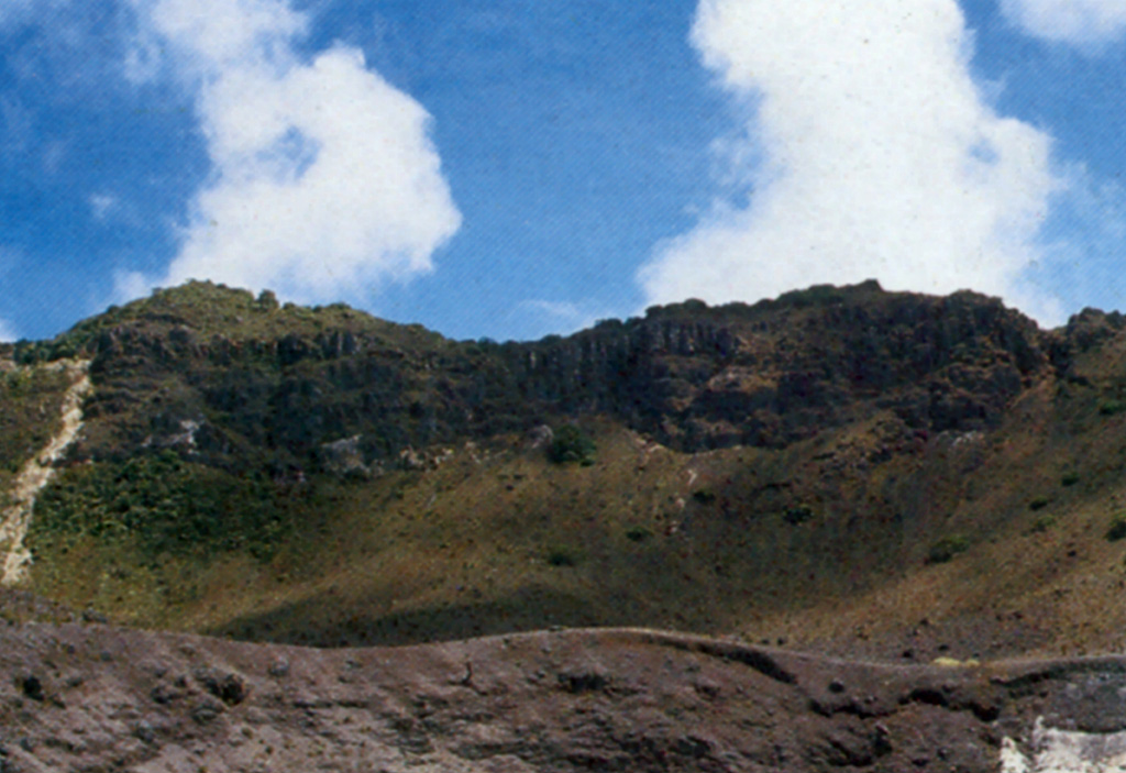 The rim of one of the three craters filling the large summit depression of Turrialba volcano is seen in the foreground. A scarp wall is visible in the background. Eruptions during the 18th and 19th centuries have originated from the three small craters. Photo by Gerardo Soto (published in Alvarado, 1989).