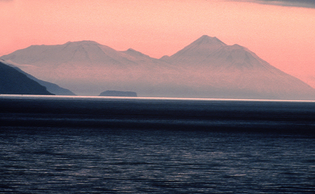 Takawangha volcano (left), seen here from the E, has an ice-filled caldera on northern Tanaga Island. Numerous small cones are located within the caldera, as well as on the rim and flanks. Tanaga volcano is to the right. Photo by Tom Edgarton, 1986 (U.S. Fish and Wildlife Service).