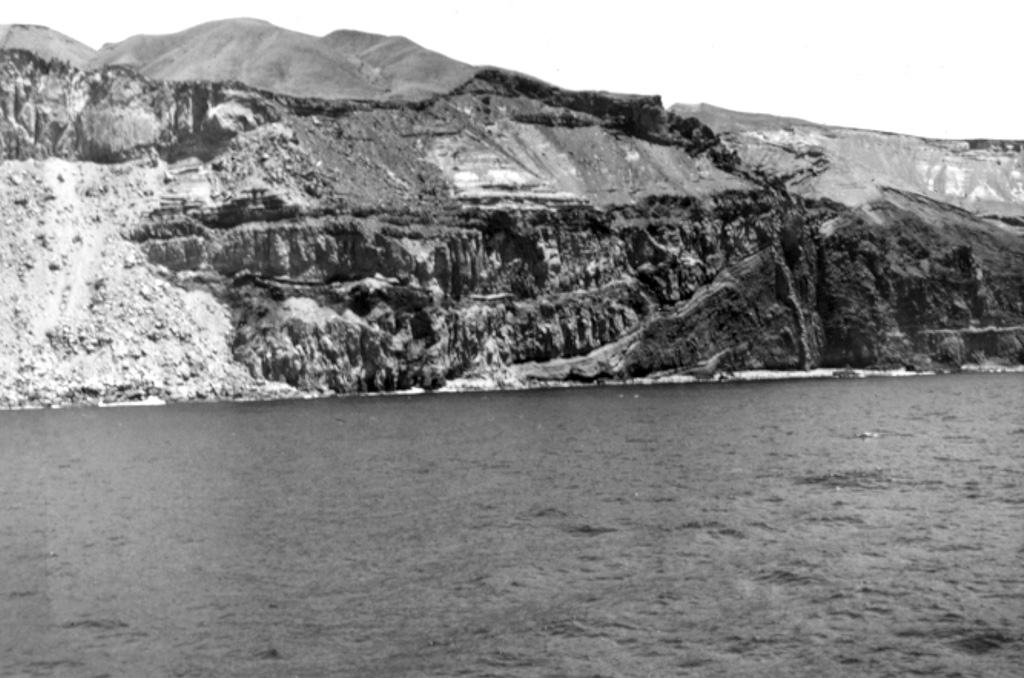 A buried valley-filling lava flow sequence is exposed in the center of the photo in a western cliff face of Guadalupe Island. Pyroclastic deposits from scoria cones are exposed above the flows. Photo by Al Segel, 1963 (courtesy of Rodey Batiza, University of Hawaii).