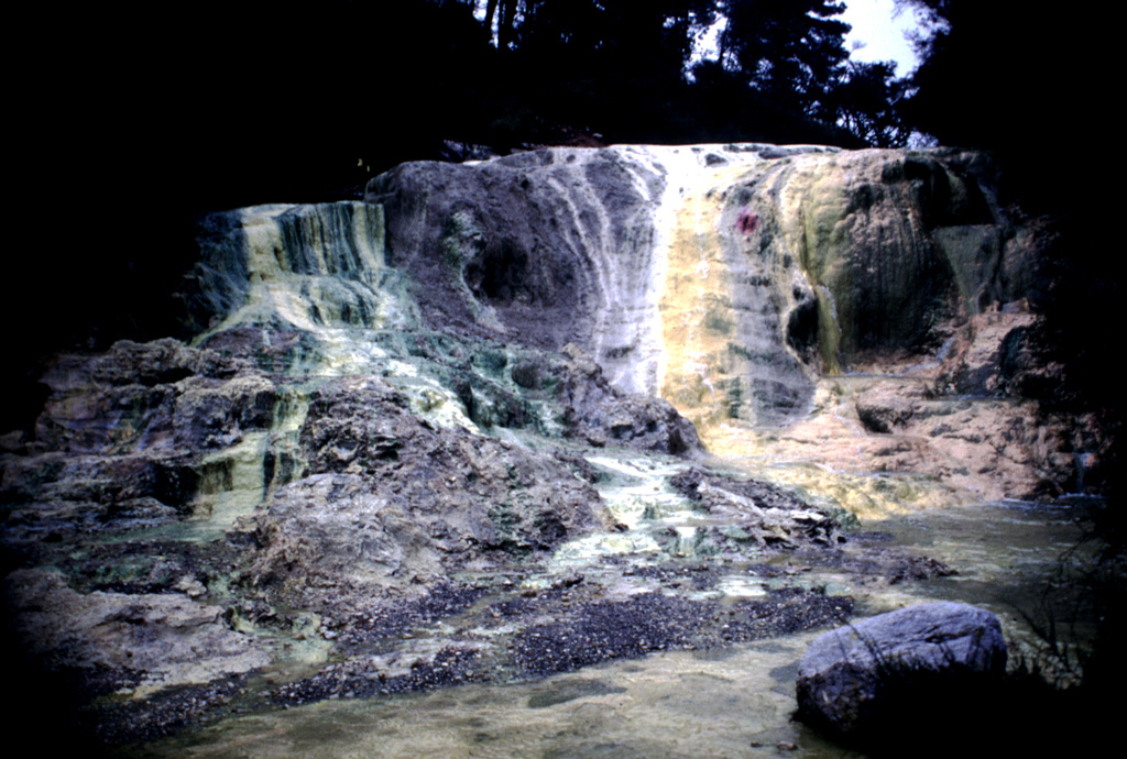 Multi-colored Bridal Veil Falls were formed from silica terraces created when mineralized water poured over from the Primrose Pool of the Wai-O-Tapu thermal area. The noted hydrothermal area lies within the 10-km-wide Reporoa caldera, which was formed during the Pleistocene in the Reporoa-Broadlands basin near the western margin of the Taupo volcanic zone. Large hydrothermal explosions took place from the Wai-O-Tapu thermal area at the time of the Kaharoa eruption of neighboring Tarawera volcano (Okataina Volcanic Centre) about 700 years ago. Photo by Richard Wysoczanski, 1994 (Smithsonian Institution).