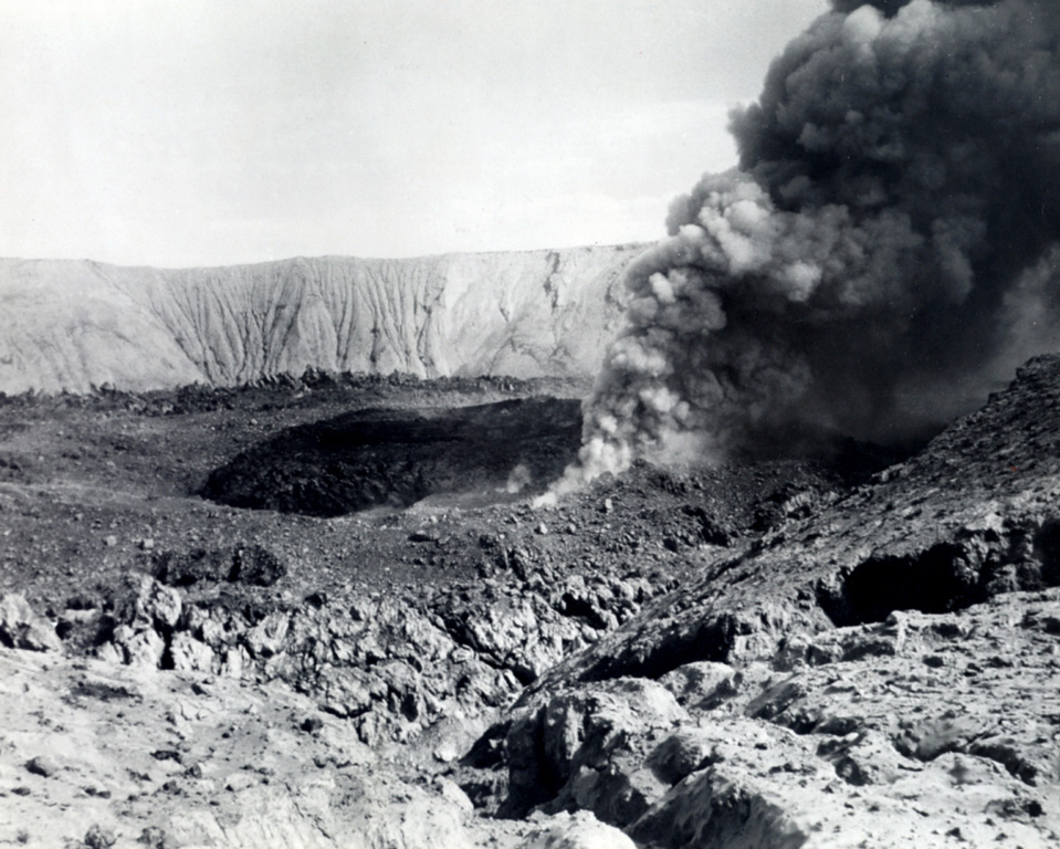 A small eruption on 10 December 1952 took place from the moat between the inner (dark-colored) and outer lava domes in the Bárcena summit crater. A lava dome was first observed on 20 September, when it was about 8 m high and 55 m wide. On 15 November the dome was observed to fill about half of the 700-m-wide crater. At the time of this photo, an older outer dome littered with breadcrust bombs and ejecta surrounded the new inner dome.  Photo by L.W. Walker, 1952 (courtesy of Sherman Neuschel, U.S. Geological Survey).