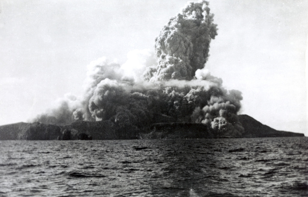 A new cone, Volcán Bárcena, was rapidly constructed during an eruption that began on 1 August 1952 at the southern end of Isla San Benedicto. This photo, taken from off the west coast of the island only four minutes after the start of the eruption, also shows the onset of pyroclastic surges. Lava extrusion occurred in September, November, and December. On 8 December activity shifted to a vent on the SE flank, producing a lava delta that extended about 700 m to sea. Activity ended in late February 1953. Photo by Robert Petrie, 1952 (U.S. Navy; courtesy of Sherman Neuschel, U.S. Geological Survey).