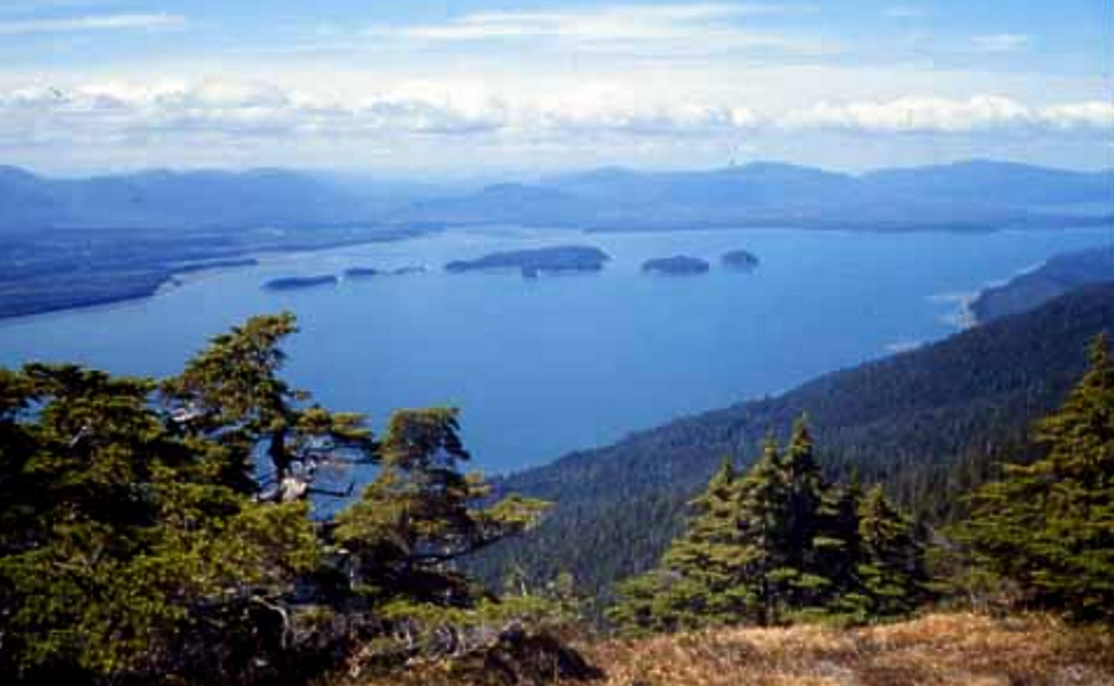 The Castle Islands (center) lie within Duncan Canal on Kupreanof Island in SE Alaska, as seen looking NW from the Lindenberg Peninsula. The Castle Islands mostly consist of Tertiary sedimentary and volcanic rocks, but the northernmost island (far-right side of the island group) contains Quaternary basalts. Pahoehoe and aa lava flows are also found at the south end of Kupreanof Island, where they overlie glacial till. Photo by Susan Karl (Alaska Volcano Observatory, U S Geological Survey).