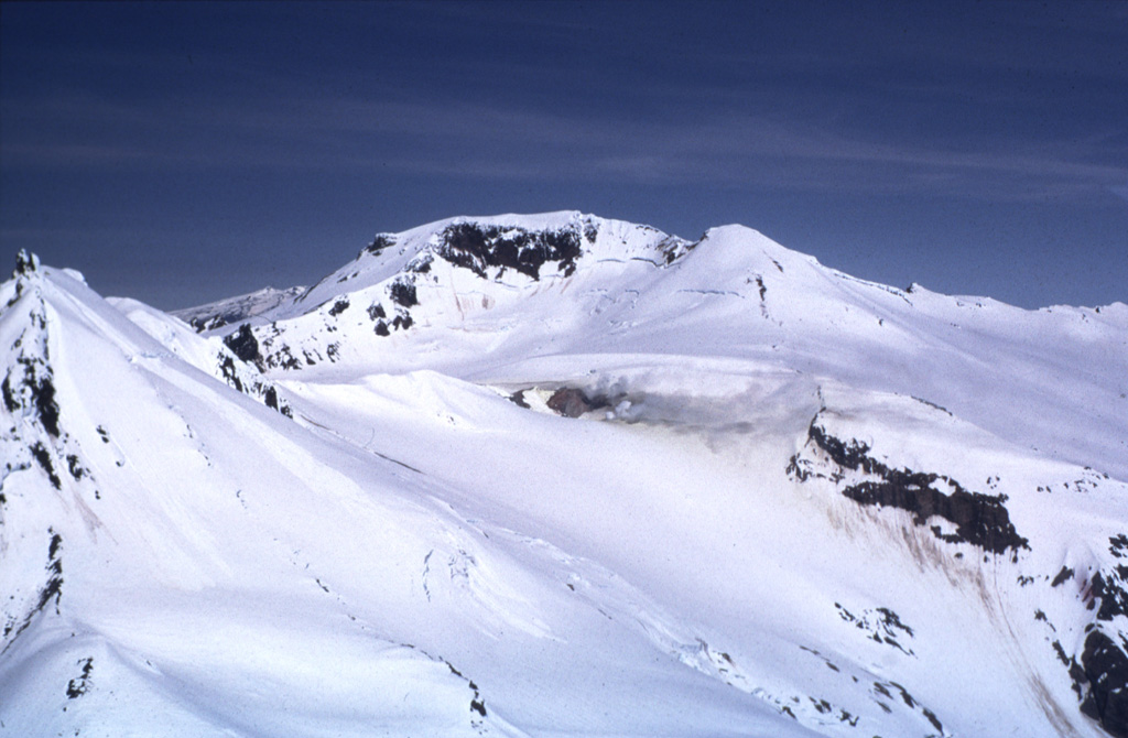 Gas-and-steam plumes (center) rise from the upper SSW flanks of Kupreanof. This is the largest and NE-most of a group of five relatively close Quaternary volcanic centers opposite Stepovak Bay. The only reported activity from Kupreanof consisted of minor steam and ash emission in 1987. Photo by Tom Miller, 1973 (Alaska Volcano Observatory, U.S. Geological Survey).