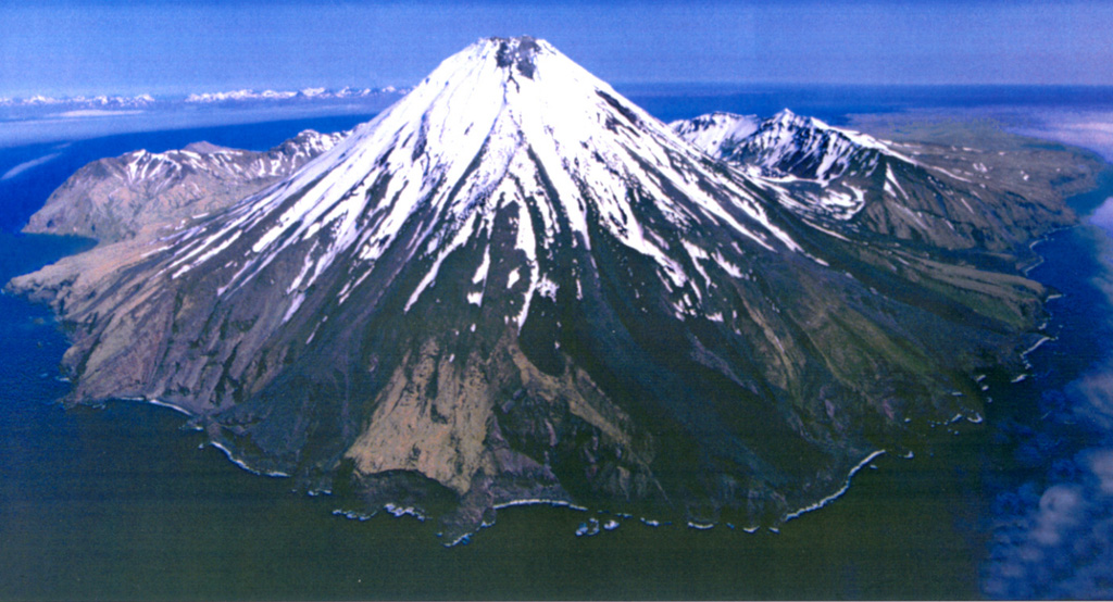 Kanaga is situated within the Kanaton caldera at the northern tip of Kanaga Island. The caldera rim forms a 760-m-high arcuate ridge, which can be seen S and E (left) of Kanaga. The two flows that reach the coast on either side of the sea cliffs in the lower center were produced during an eruptive period from mid-1993 through 1995. Photo by Chris Nye, 2000 (Alaska Division of Geological & Geophysical Surveys, Alaska Volcano Observatory).