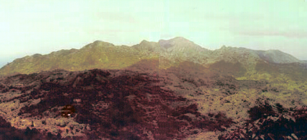 The southern end of the elongated Mount St. Catherine volcanic complex on the island of Grenada is seen here from the Southeast Mountain area.  The island is composed of five Pliocene-to-Pleistocene volcanic centers, the youngest and highest of which is 840-m-high Mount St. Catherine on the northern end of the island. The most recent activity originated from a group of young maars, tuff rings, and scoria cones extending across the length of the island.  These include Grand Etang crater, which lies near the crest of the skyline ridge.  Photo by Richard Arculus, 1973 (Seismic Research Unit, University of West Indies).