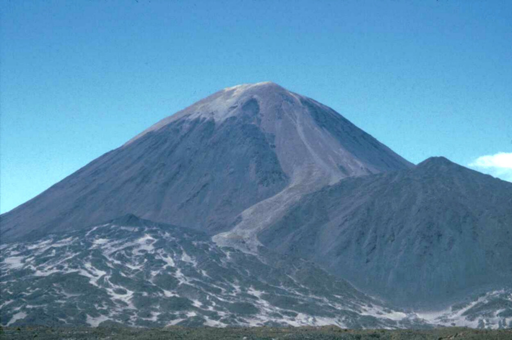 Lighter-colored pyroclastic material blankets the summit of Cerro Peinado, and a possible pyroclastic-flow deposit descends the right-hand flank. This symmetrical Argentinian stratovolcano, one of the youngest in the region, is the source of well-preserved lava flows of Holocene age from summit and flank vents.  An apron of pristine lava flows surrounds the volcano and was erupted from the main cone and from vents on the flank, including a prominent ESE-flank vent.  Photo by Ben Edwards, 1998 (Dickinson College, Pennsylvania).
