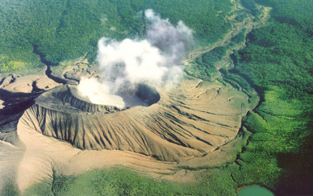 A steam plume rises from Cráter Activo of Rincón de la Vieja, seen here from the south with an acidic crater lake filling the innermost of two nested craters. Frequent eruptions and acid rain have kept the flanks of the cone unvegetated. Remobilization of fresh deposits has produced lahars down the Quebrada Azufrosa to the upper right. Photo by Federico Chavarria Kopper, 1999.