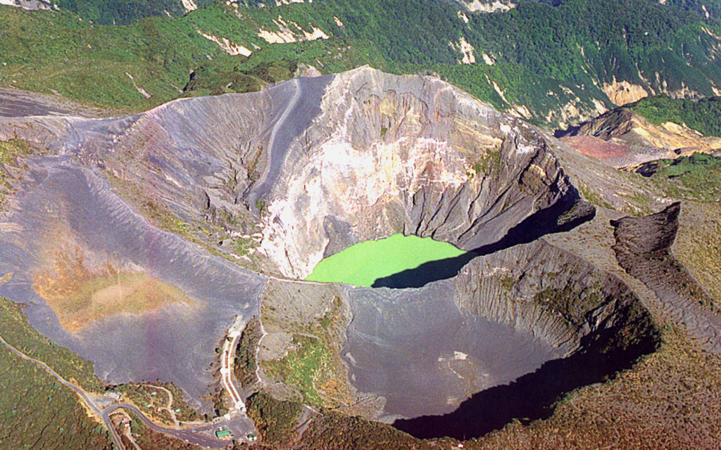 An aerial view from the SE looks down on the Irazú summit crater complex in 1999. Three craters are visible here, the 700-m-wide main crater with a green lake, the Diego de la Haya crater (lower right), and the older Playa Hermosa crater (lower left).  Photo by Federico Chavarria Kopper, 1999.