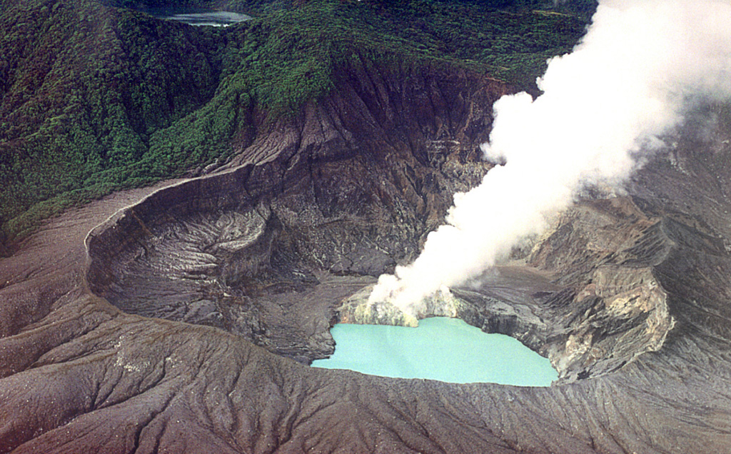 A gas plume rises from the lava dome on the south side of the Poás summit crater lake in this February 2000 view from the NW. Degassing produced plumes up to about 700 m high in May and bubbling within the crater lake had been reported since late March. Temperatures of around 40°C were measured on the NE shore of the lake at various points in May. The 400-m-wide Laguna del Fría is visible at the upper left within the Botos crater. Photo by Federico Chavarria Kopper, 2000.