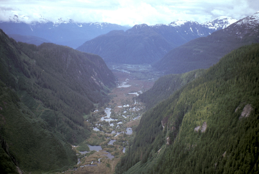 Shallow ponds are seen across the surface of valley-filling lava flows of the Iskut-Unuk volcanic field. The flows traveled south 5 km where they crossed the border into Alaska and dammed the Blue River, forming several small lakes and traveling a total of approximately 22 km. The Iskut-Unuk River Cone Group consists of eight small basaltic centers at the southern end of the Stikine volcanic belt that range in age from about 70,000 to only a few hundred years old and form one of the youngest volcanic fields in Canada. Photo by Ben Edwards, 1997 (Dickinson College, Pennsylvania).