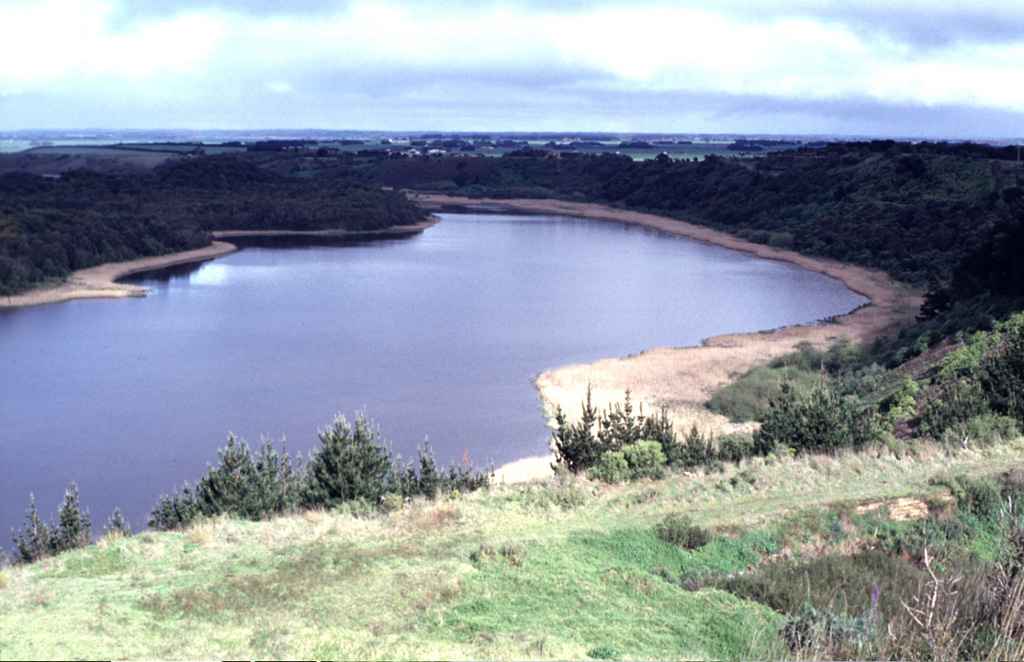 Lake-filled Tower Hill maar is part of the voluminous Newer Volcanics Province, which covers a broad 15,000 km2 area of SE Australia. The volcanic field contains nearly 400 vents, with late-Pleistocene to Holocene eruptions producing scoria cones, maars, tuff rings, and valley-filling lava flows. The most recent eruptions took place at Mount Schank and Mount Gambier. Photo by Jim Luhr, 1993 (Smithsonian Institution).