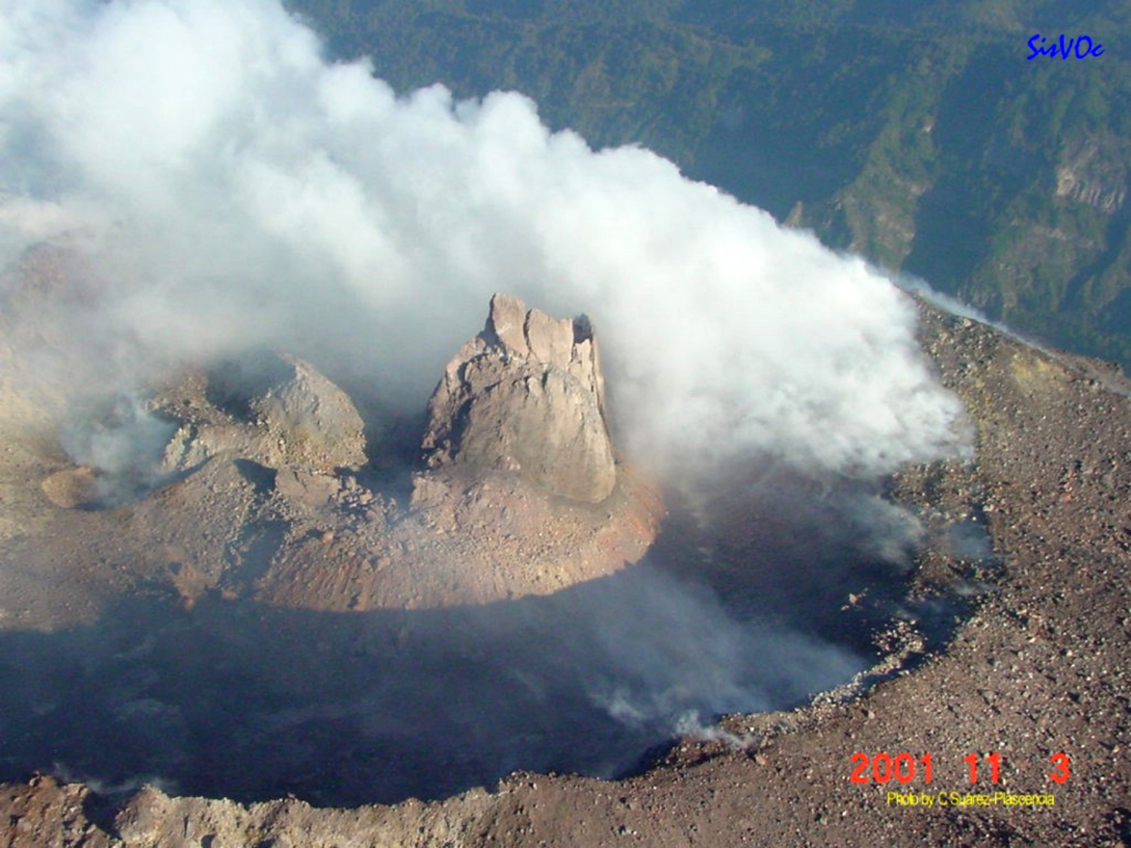 On 3 November 2001 this lava dome was observed on the north side of Colima's summit crater with a spine forming at the top. The spine was about 40 m tall, 40 m wide at its base, and smooth with vertical walls. Extrusion of this new dome had begun in early October and continued with a high extrusion rate, reaching a maximum on 14 October. This was part of a long eruption that began in November 1997 and was accompanied by small explosions.  Photo courtesy of Centro de Sismologia y Volcanología de Occidente, Centro Universitario de la Costa, 2001.