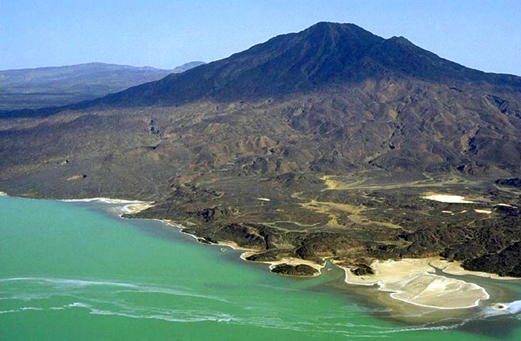 Borawli stratovolcano is located E of Lake Giulietti (also known as Lake Afrera). The upper part of the volcano, seen here from the NW, consists of trachytic lava flows overlying basaltic flows. Young obsidian domes south of the volcano are the likely source of rounded pumice fragments found around the lake.  Copyrighted photo by Marco Fulle, 2002 (Stromboli On-Line, http://stromboli.net).