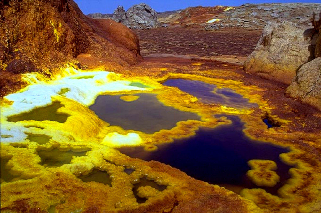 Colorful hot brine pools up to about a meter in diameter with terraces at hot springs at Dallol. Numerous phreatic explosion craters dot the Salt Plain NNE of the Erta Ale Range in one of the lowest areas of the Danakil depression. These craters mark Earth's lowest known subaerial volcanic vents. The most recent of these craters, Dallol, lies 48 m below sea level and was formed during an eruption in 1926. Copyrighted photo by Marco Fulle, 2002 (Stromboli On-Line, http://stromboli.net).