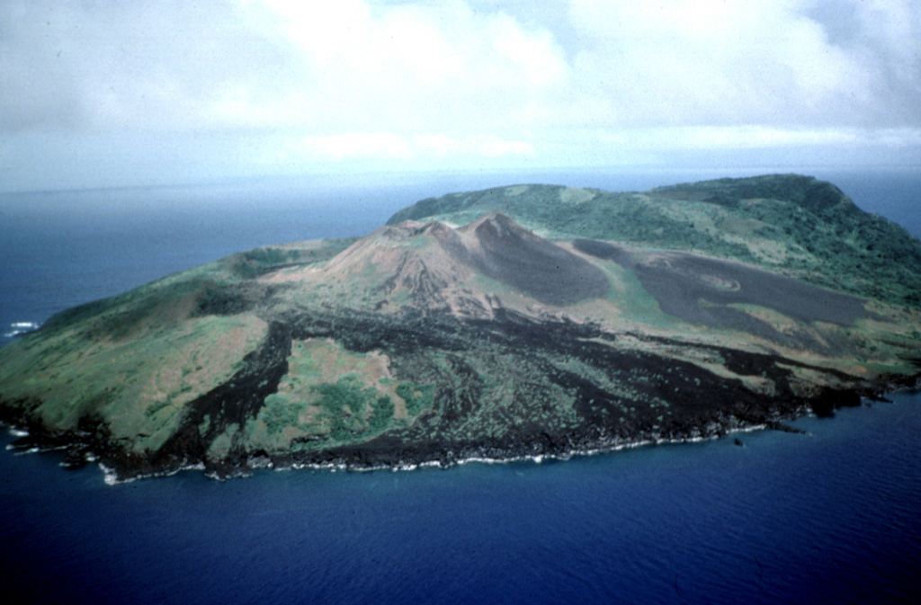 The 2.8-km-wide Guguan island in the central Marianas Islands, seen here from the NW, is composed of an eroded volcano at the south and a caldera with a post-caldera cone. The northern cone (foreground) was the site of an eruption in the 19th century. It has three coalescing cones and a summit crater that produced lava flows to the W and NW. Photo by Dick Moore, 1992 (U.S. Geological Survey).