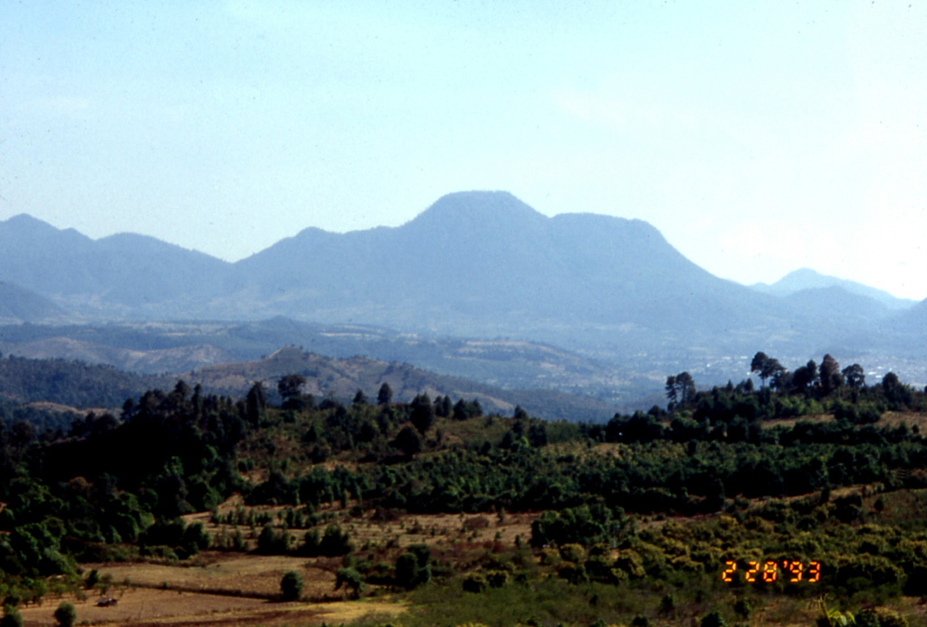 This view from the north shows the Cerro el Cacique lava dome, part of the extensive Zitácuaro-Valle de Bravo volcanic field in the central Mexican Volcanic Belt. The dome rises over the city of Heroica de Zitácuaro, which is built on top of a deposit originating from collapse of the Cerro Pelón lava dome (visible to the left of the Cacique dome). Andesite lava flows to the south in the Valle de Bravo area are as young as about 5,000 years. Photo by Lucia Capra, 1993 (courtesy of José Macías, Universidad Nacional Autónoma de México).