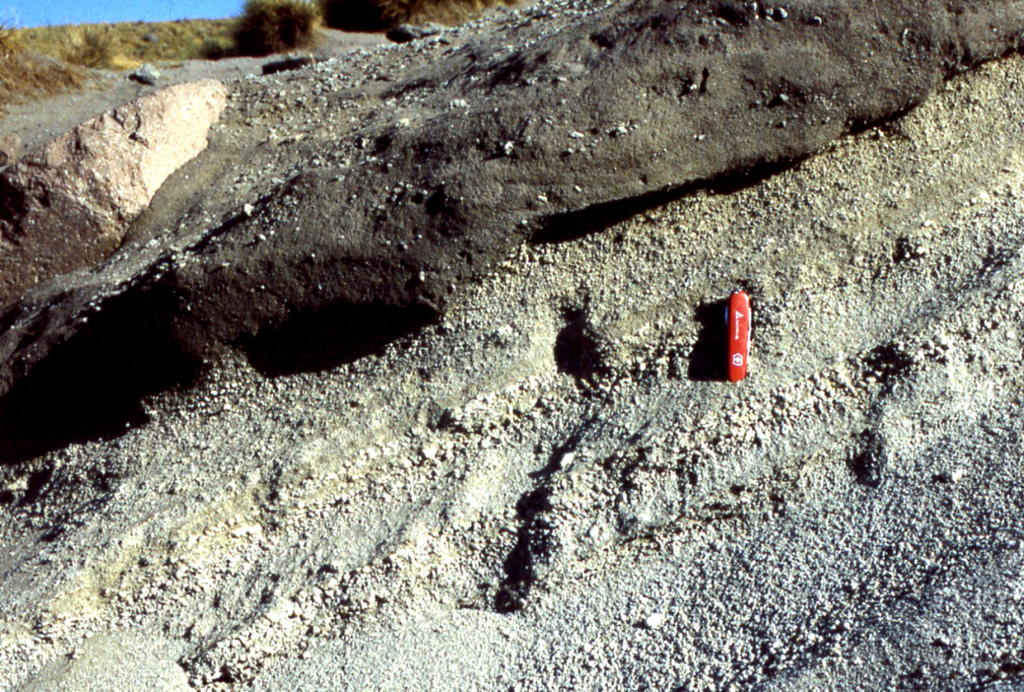 The products of the last major eruption of La Malinche that occurred about 3,100 years ago are exposed around the summit area and consist of a weakly stratified pumiceous ash and fine lapilli layer, along with associated pyroclastic flow and lahar deposits. Lahars originating from La Malinche reached the Puebla basin and contain pottery fragments, indicating that nearby communities were affected by the eruption. The pocket knife provides scale. Photo by Renato Castro, 2000 (courtesy of José Macías, Universidad Nacional Autónoma de México).