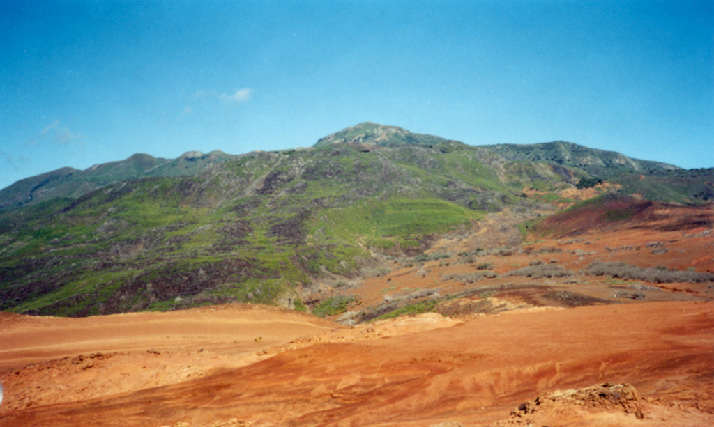 The summit cone and lava dome complex of Cerro Evermann is viewed here from the SE flank. Obsidian lava domes and flows of rhyolite and trachyte composition have filled most of the summit craters. Cerro Evermann formed within the 4.5 x 3.8-km-wide, 370,000 year old Pleistocene caldera. The caldera rim is exposed at about 600 m elevation on the south and east sides of Cerro Evermann, where it forms a 20-50 m high scarp. Photo by Martha Marin, 1998 (Mexican Navy).