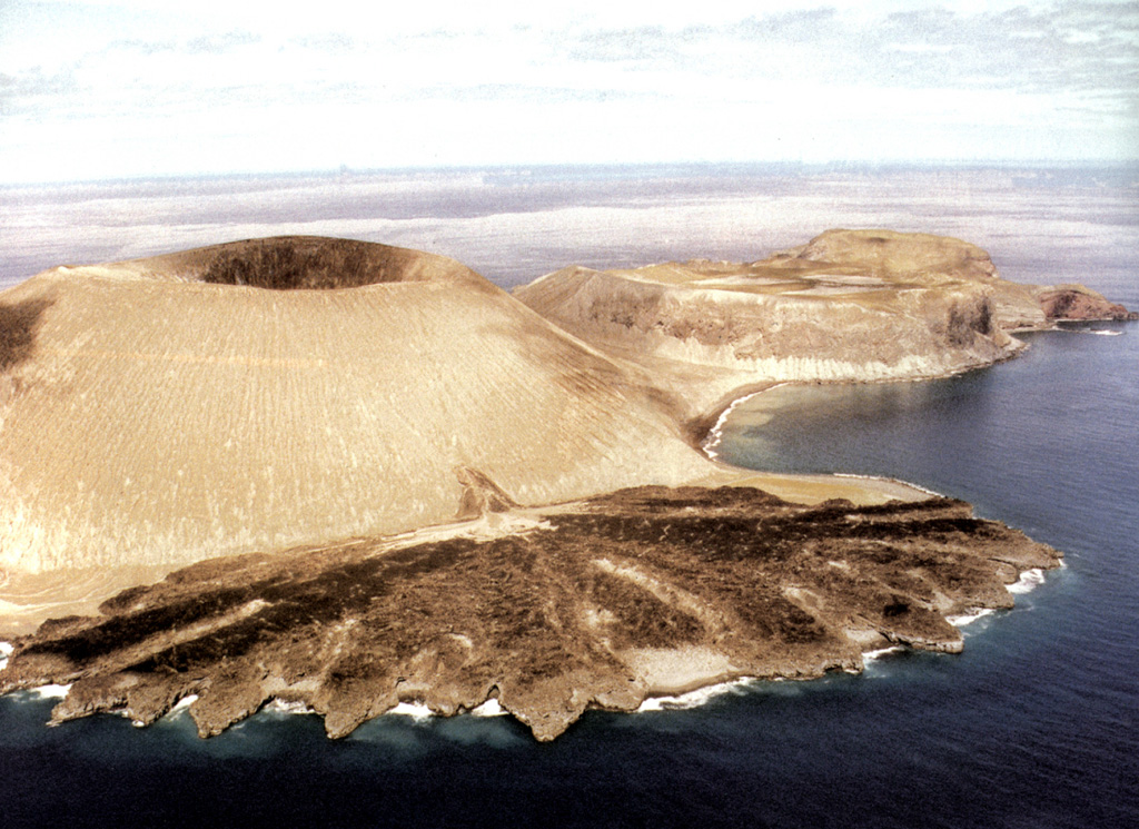 The Delta Lávico flow forms a peninsula on the SE flank of Volcán Bárcena at the southern end of San Benedicto Island. The tuff cone and lava flow formed during the 1952-53 eruption. The flat-topped cone to the right is Cráter Herrera, a lava dome with crater. Another lava dome, Roca Challenger, forms the northern tip of the island beyond Cráter Herrera. Photo by Hugo Delgado-Granados, 1993 (Universidad Nacional Autónoma de México).