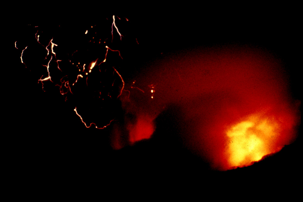 An incandescent pyroclastic flow (lower right) travels down the flanks of El Chichón with lightning produced in the ash plume (left) on 3 April 1982. Minutes later this plume reached an altitude of about 24 km. The eruption of large amounts of tephra and pyroclastic flows and surges caused extensive damage and fatalities. Explosive removal of the summit lava dome created a new 1-km-wide, 300-m-deep crater. Photo by Servando De la Cruz-Reyna, 1982 (Universidad Nacional Autónoma de México).