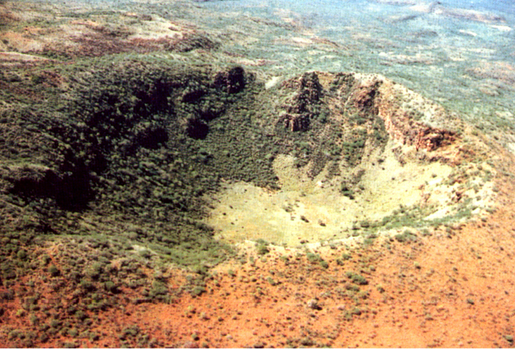 Getang crater, also known as Kinyach, is on the N side of the Korosi summit area. The walls of the 600-m-wide, 120-m-deep crater expose trachytic lava flows. The youngest activity at Korosi, consisting of fissure-fed basaltic lava flows on the lower northern flanks, may have occurred only a few hundred to a few thousand years ago. Photo by Martin Smith, 1993 (copyright British Geological Survey, NERC).