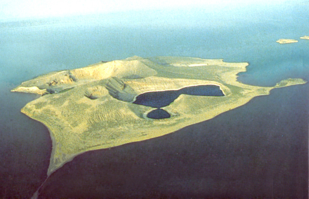 A compound lake-filled crater occupies the SW side of Central Island in the middle of Lake Turkana. A small young crater (left central) cuts the northern rim of the tuff ring, and another large crater lies behind it. These lakes partially fill craters up to 1 km wide and about 80 m deep, with the floors near sea level. The small islands (upper right) south of Central Island are part of the volcanic complex, and other cones lie beneath the lake surface. Photo by Martin Smith, 1993 (copyright British Geological Survey, NERC).