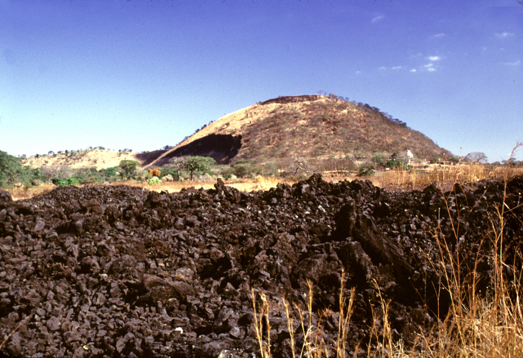 El Playón scoria cone on the lower NW flank of Santa Ana formed during an eruption in 1658. The eruption began on 3 November 1658, producing ashfall in Comayagua and a lava flow (left) to the NE that surrounded the village of Nejapa. The lava flow in the foreground was emplaced in 1917 from a vent on the upper northern flank of San Salvador. Photo by Lee Siebert, 2002 (Smithsonian Institution).
