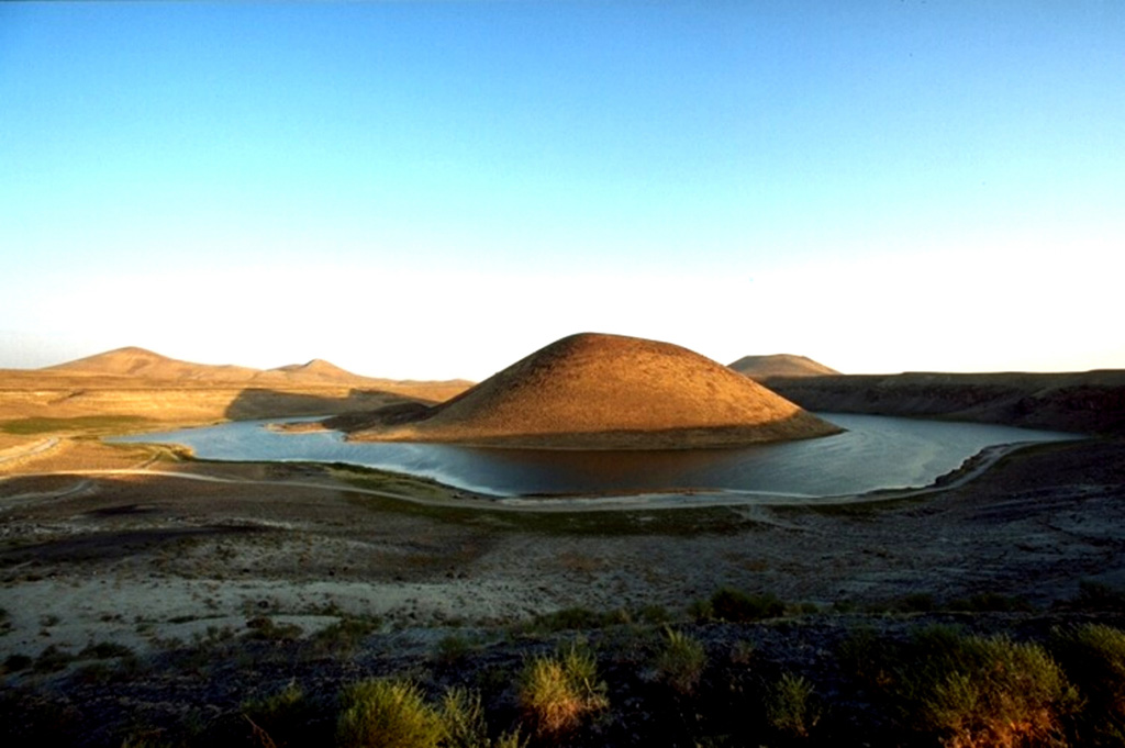 Meke Golu lake surrounds the Meke Dagi scoria cone in the Karapinar volcanic field, which is comprised of cones, lava fields, and maars on the Konya-Eregli plain. The 300-m-high Meke Dagi is one of the largest cinder cones in Central Anatolia. This maar complex evolved from a hyaloclastite tuff ring to a maar to a scoria cone, reflecting varying lake water levels during the eruption. Copyrighted photo by Marco Fulle, 1999 (Stromboli On-Line, http://stromboli.net).