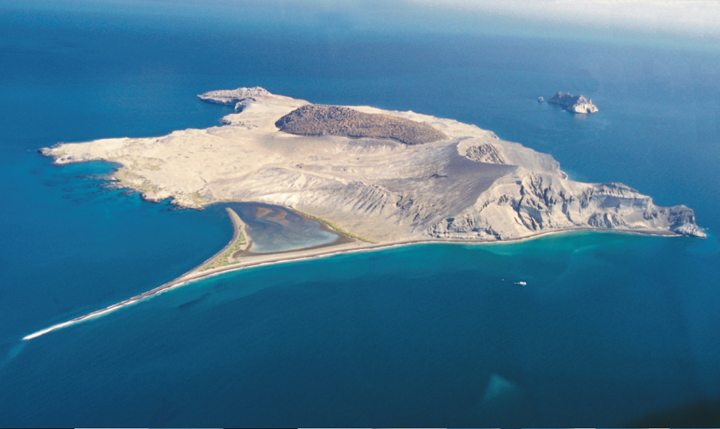 Isla San Luis is seen here from the south with a 2-km-long spit (at low tide) to the lower left. The main features of the island are a rhyolite lava dome forming the NW tip of the island, the darker rhyolitic obsidian dome and coulee in the center, and an eroded tuff ring at the SE tip of the island (to the right). Another tuff ring, Isla Poma, lies 1 km NE of Isla San Luis and is visible to the right. Photo by Brian Hausback, 2000 (California State University, Sacramento).