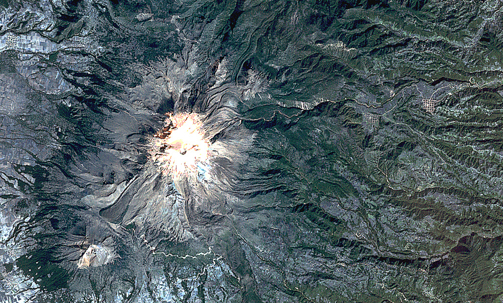 Pico de Orizaba (Volcán Citlaltépetl) formed on the margin of the Altiplano and has substantially higher relief on its eastern (right) side. Debris avalanches and lahars produced by edifice collapse have swept down the eastern flanks onto the coastal plain. A lava flow with lateral levees is visible on the lower SW flank below the summit. The eroded peak to the lower left beyond the lava flow terminus is Sierra Negra, the southernmost peak of the Cofre de Perote-Orizaba volcanic chain. NASA Landsat satellite image, 1999 (courtesy of Loren Siebert, University of Akron).