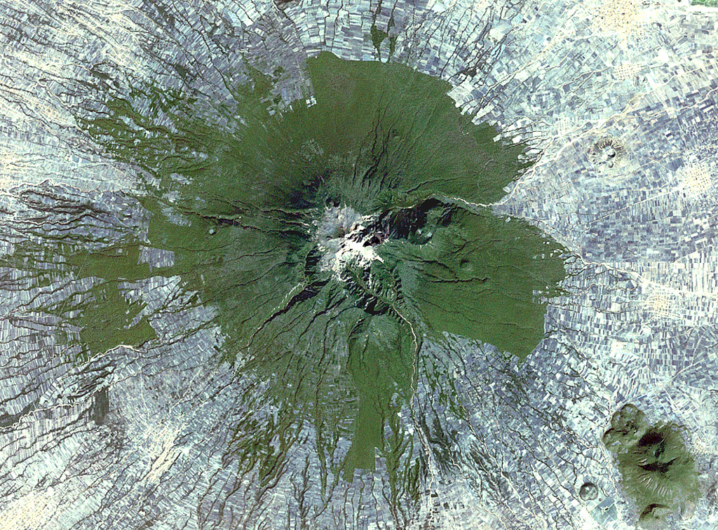 Farmlands surround La Malinche volcano NE of the city of Puebla in this 1999 Landsat satellite image (N is at the top; this image is approximately 30 km across). Deep erosional gullies have formed down the flanks, and the 1.5-km-diameter late-Pleistocene Xalapasco maar complex is on the lower ENE Flank about 11 km from the summit.  NASA Landsat satellite image, 1999 (courtesy of Loren Siebert, University of Akron).