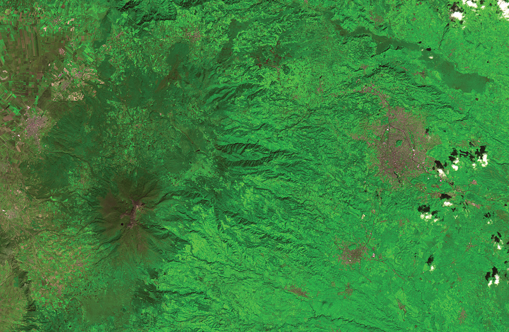 The flanks of the massive Cofre de Perote shield volcano extend across most of the left two-thirds of this satellite image.  The summit of the volcano (lower left) has been truncated by edifice failure to the east.  The large brown area at the middle right is Jalapa, the capital city of the state of Veracruz; to its SW is the city of Coatepeque.  The voluminous dark-colored Río Naolinco lava flow north of Jalapa originated from a vent on the lower NE flank of Cofre de Perote about 900 years ago and traveled an additional 15 km beyond the margin of this image. ASTER satellite image, 2001 (National Aeronautical and Space Administration, processed by Doug Edmonds).